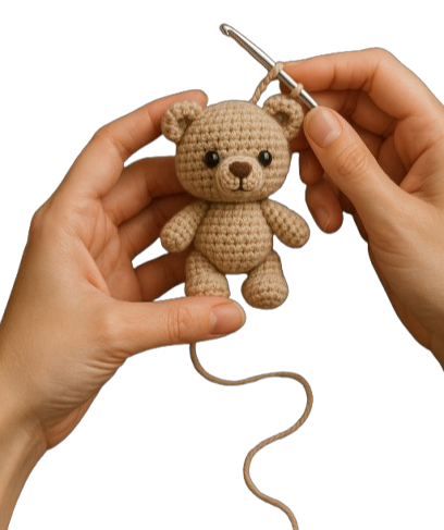 Mani che lavorano un piccolo orsetto amigurumi all'uncinetto